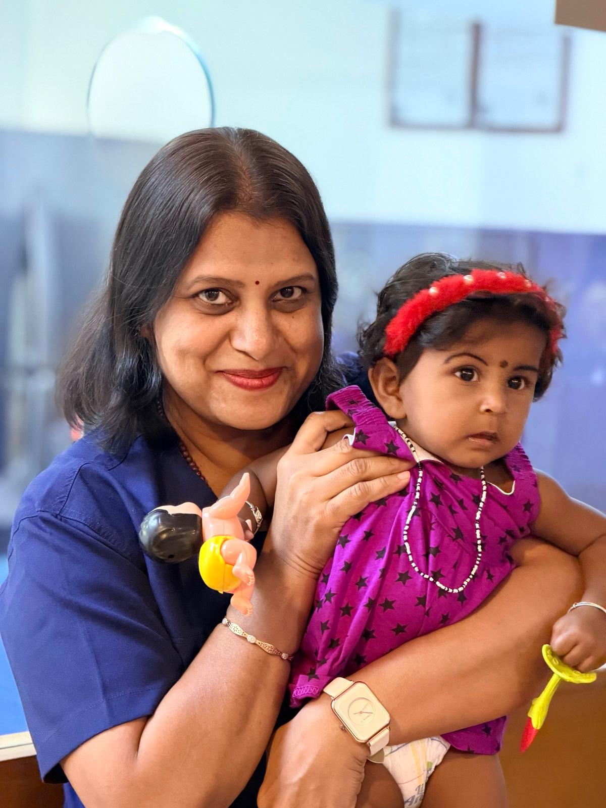 Dr. Sandhya welcoming a baby during a clinic visit