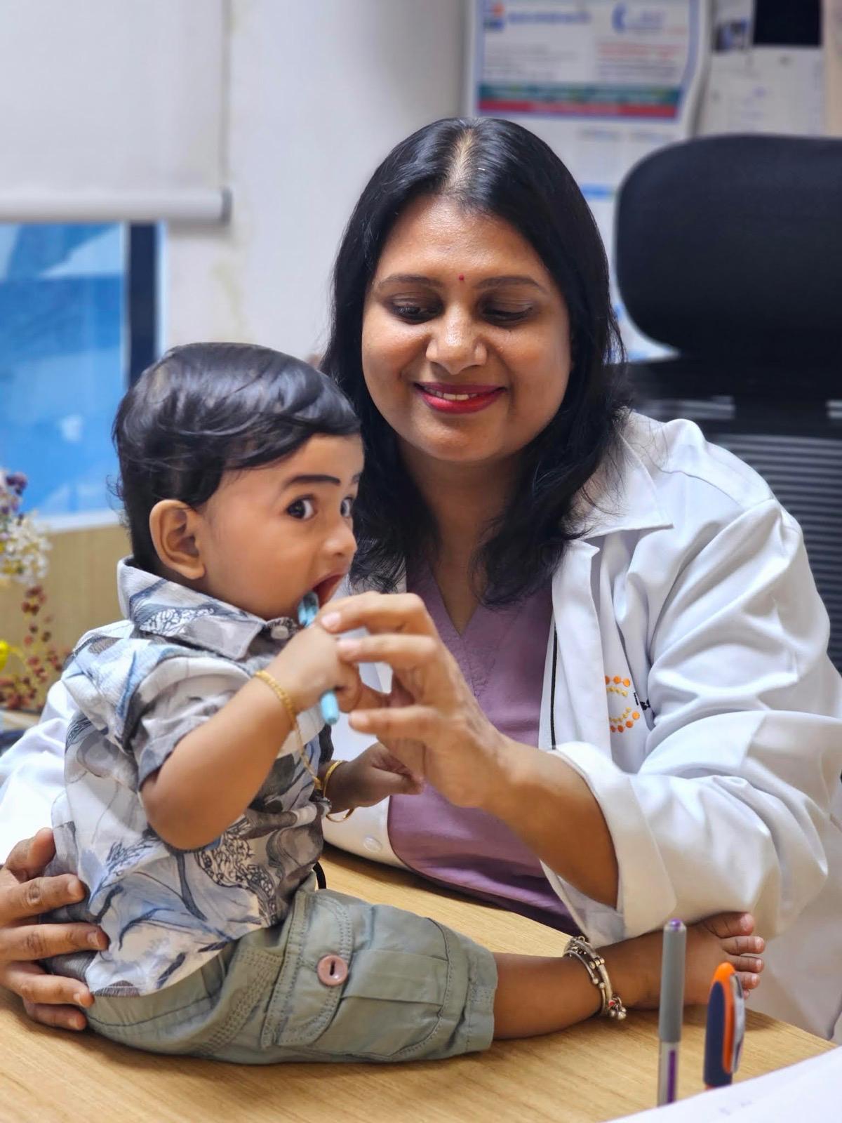 Dr. Sandhya in her consultation room with a young child